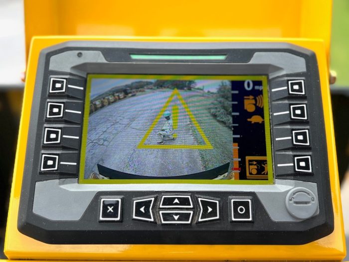 Guardman personnel and equipment proximity and automatic emergency braking operator display screen showing the first warning stage with an asphalt worker shown in the rear view camera monitor.