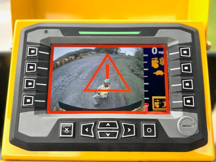 Guardman personnel and equipment proximity and automatic emergency braking operator display screen showing the second warning stage with an asphalt worker shown in the rear view camera monitor.