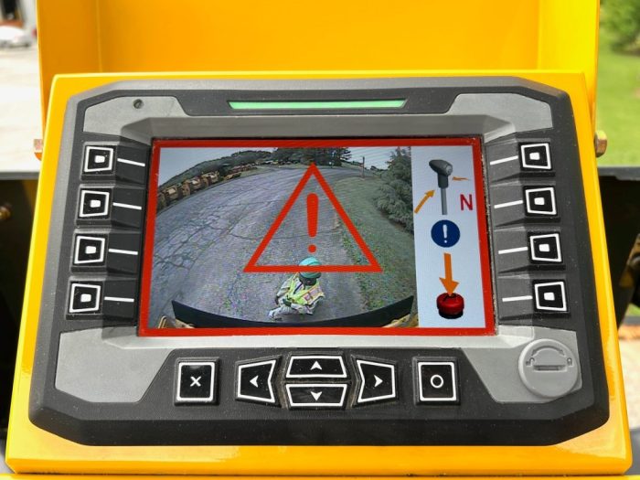 Guardman personnel and equipment proximity and automatic emergency braking operator display screen showing the final stopping stage with an asphalt worker shown in the rear view camera monitor plus the on screen reset instructions.