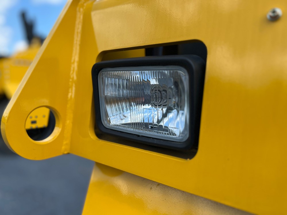 Close up of front standard halogen light assembly on the SAKAI GW754 vibratory pneumatic tire roller or traffic roller.