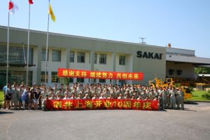 Employees pose in front of the Sakai Heavy Industries Shanghai China factory.