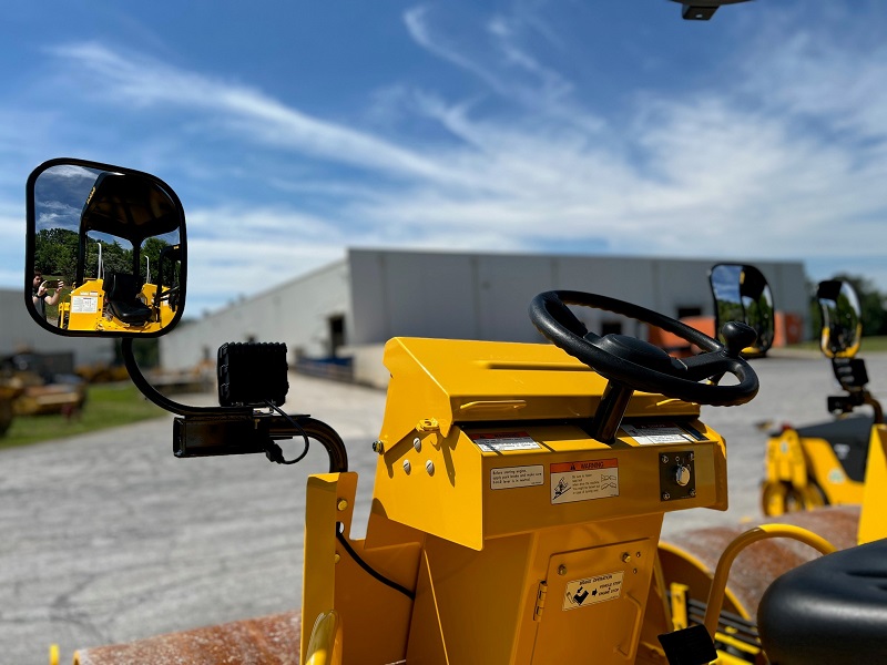 Operator's view of the optional mirror kit installed on a SAKAI SV204 roller compactor which also shows the back of the optional LED work lights.