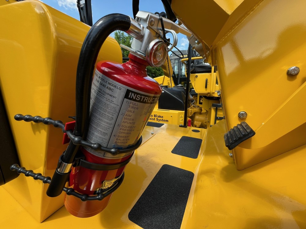 Optional fire extinguisher mounted to the SAKAI SV414 soil compactor's right hand operator console.