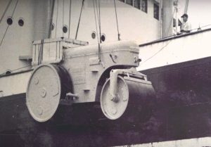 A Sakai road roller is lowered by crane from a shipping vessel in Thailand in 1935.
