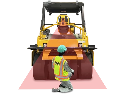 Rear view of a SAKAI GW754G vibratory pneumatic tire roller or PTR equipped with the automatic emergency braking system called Guardman with a paving worker behind the machine within a detection beam.